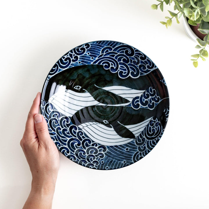 A pasta bowl decorated with blue and white whales and waves.