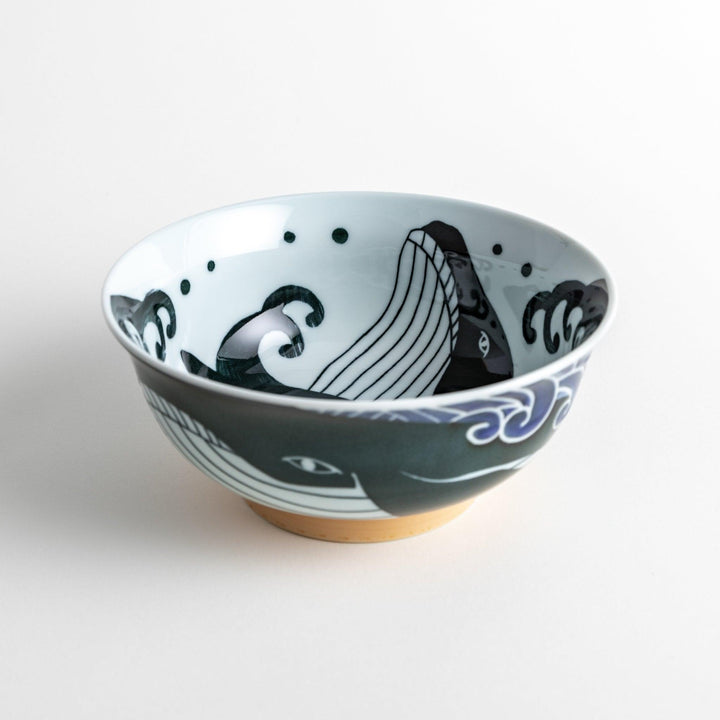 A ramen bowl with a white and blue design, featuring a whale illustration and wave patterns.