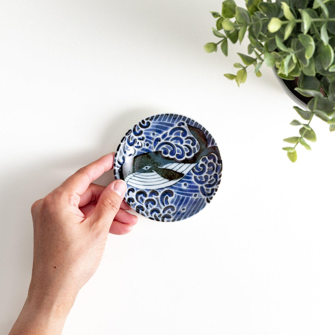 A small sauce dish with a detailed blue and white whale design, perfect for condiments.