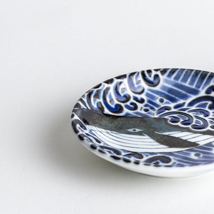 A small sauce dish with a detailed blue and white whale design, perfect for condiments.