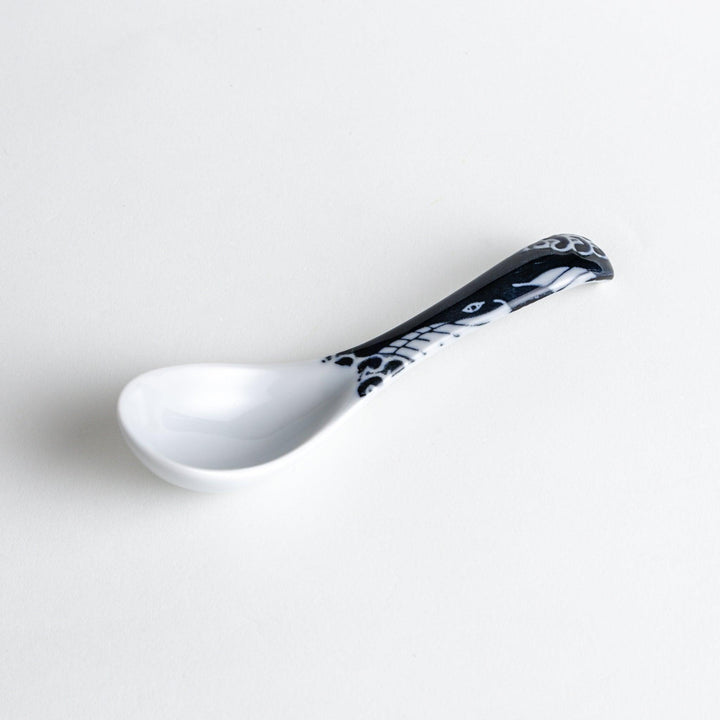 A porcelain soup spoon with a blue wave pattern on the handle.