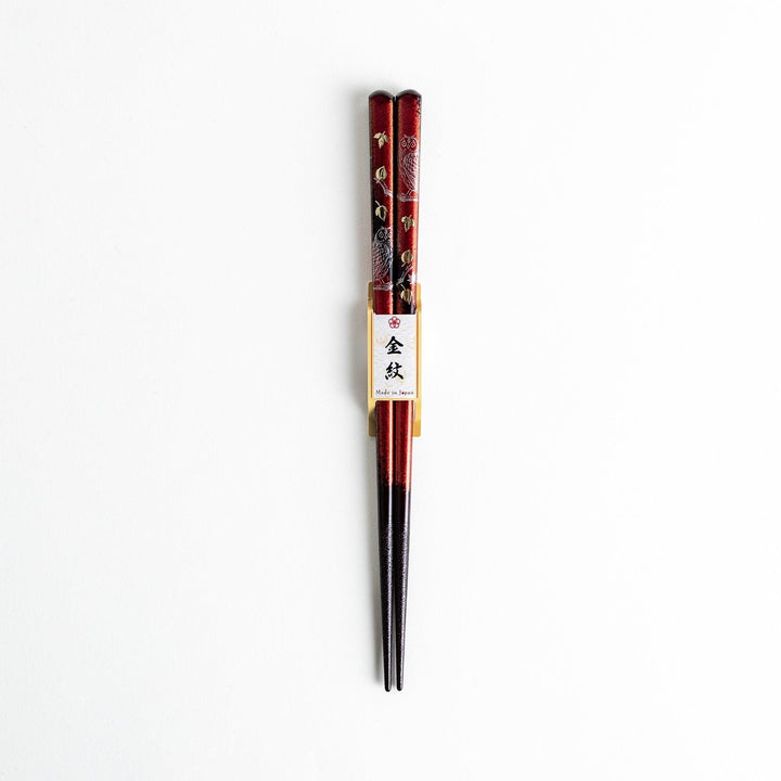 Two pairs of chopsticks in black and red, with golden owl and leaf designs and Japanese text inscriptions.